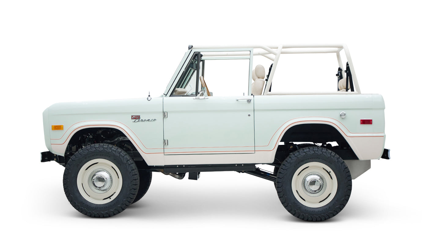 Side profile of white Classic Ford Bronco 1974 Diamondblue Coyote Series with off-road tires