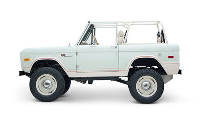 Side profile of white Classic Ford Bronco 1974 Diamondblue Coyote Series with off-road tires