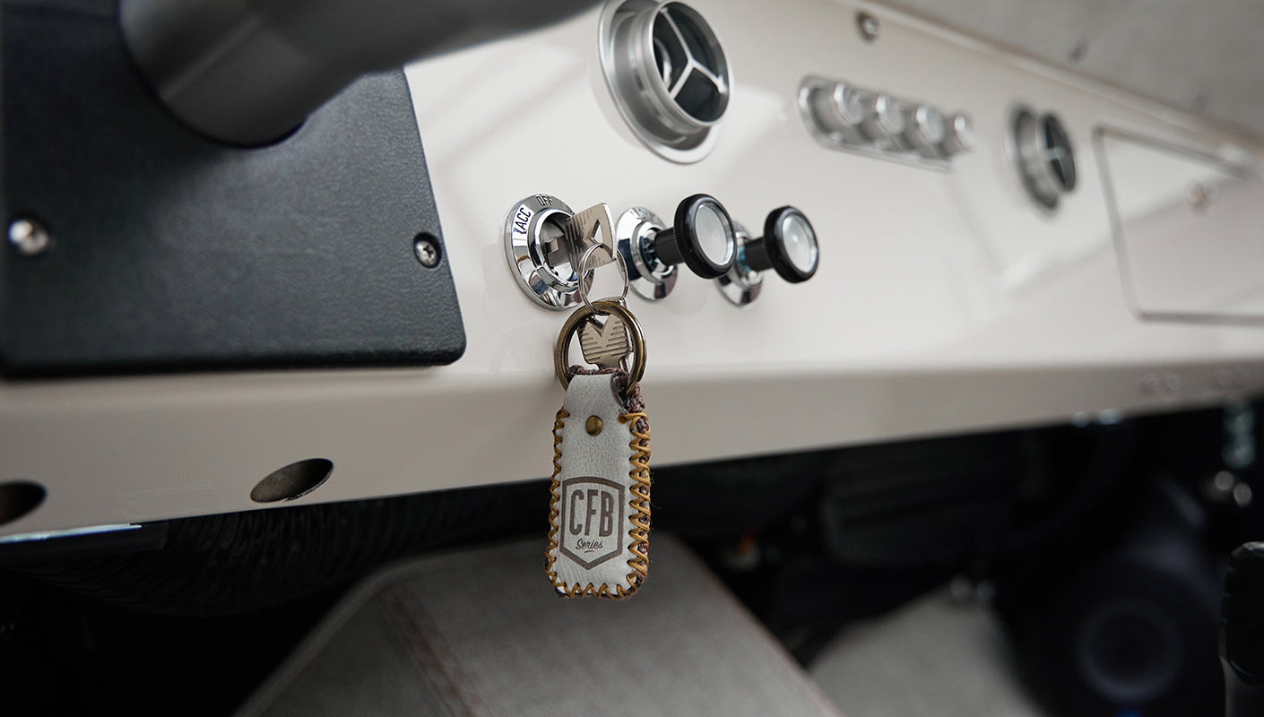 Classic Ford Bronco dashboard with ignition key and leather keychain hanging from the ignition switch.