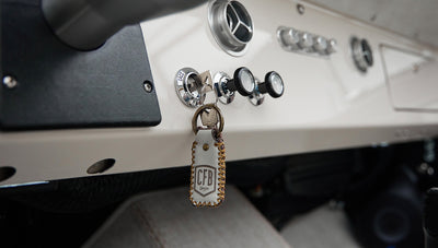 Classic Ford Bronco dashboard with ignition key and leather keychain hanging from the ignition switch.