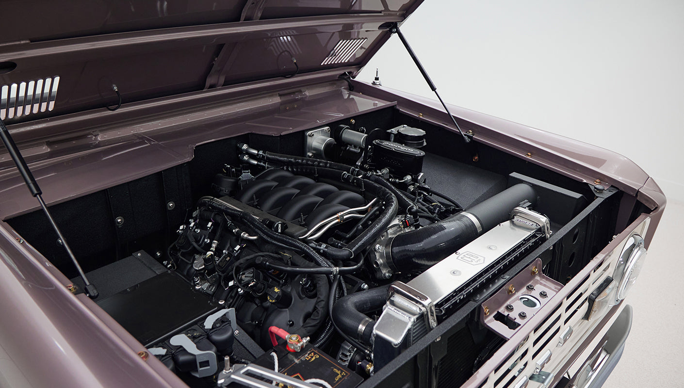 Open hood showing engine and components of Classic Ford Bronco