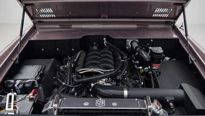 Close-up of engine bay with multiple hoses and components inside Classic Ford Bronco
