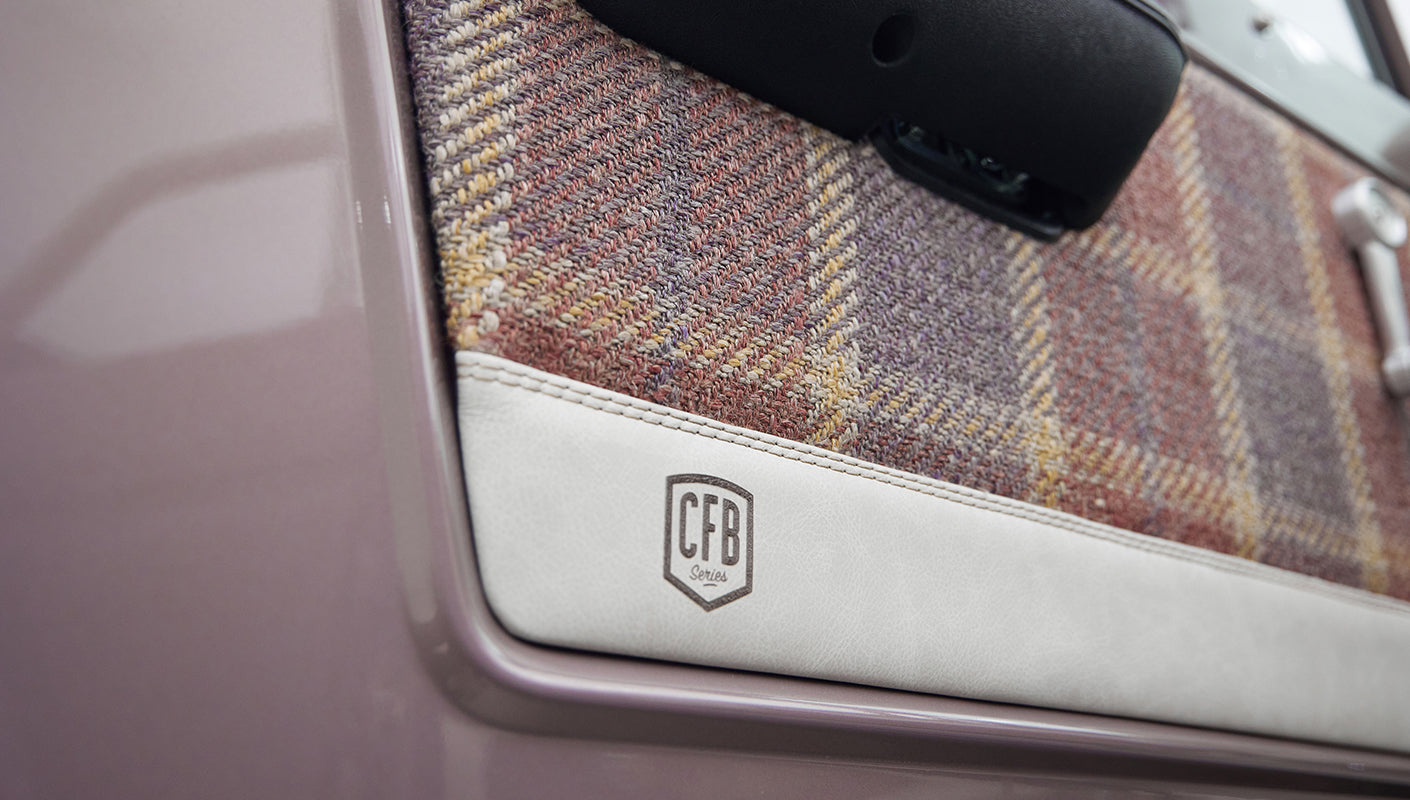 Close-up of Classic Ford Bronco door panel with plaid fabric and CFB Series emblem