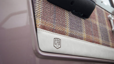 Close-up of Classic Ford Bronco door panel with plaid fabric and CFB Series emblem