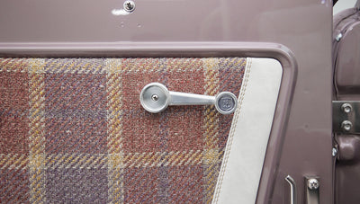 Detail of Classic Ford Bronco door panel fabric plaid pattern and window crank with CFB logo