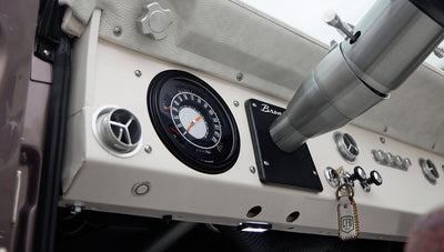 Dashboard and interior of Classic Ford Bronco showing white and plaid upholstery and manual gear levers