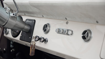 Wide interior view of Classic Ford Bronco showing seats, steering wheel, dashboard, and door panel