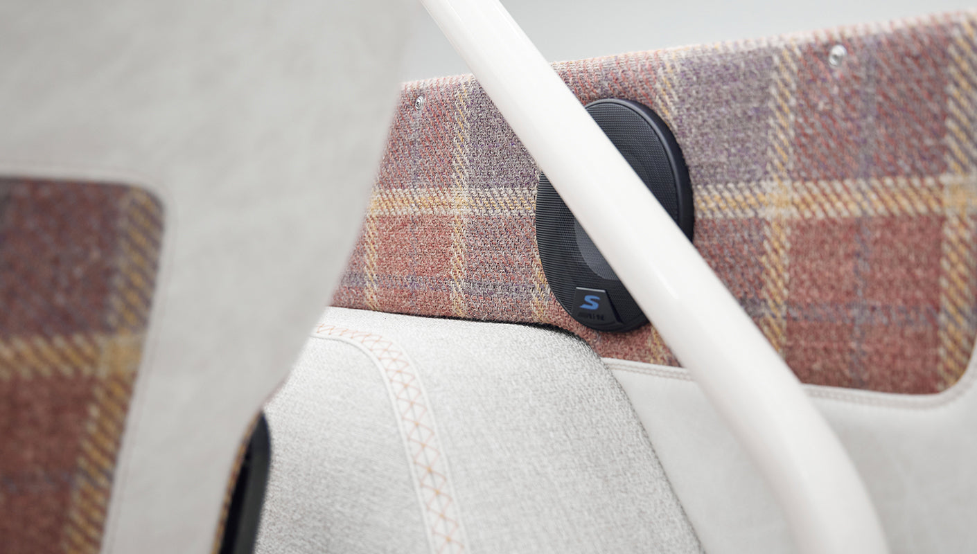Close-up of speaker mounted on plaid panel inside a Classic Ford Bronco