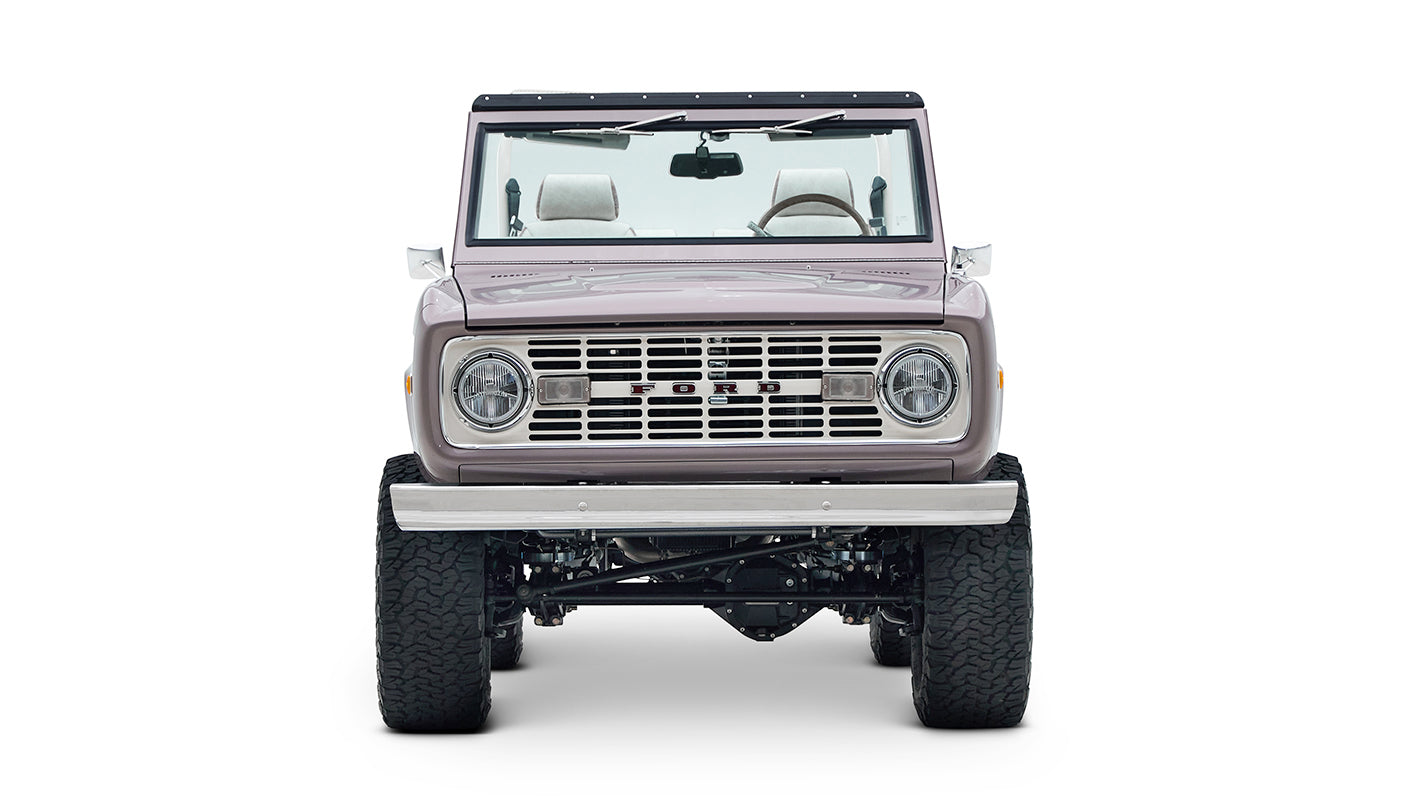 Front view of Classic Ford Bronco in light muted purple with off-road tires and exposed suspension