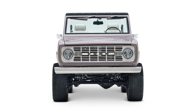 Front view of Classic Ford Bronco in light muted purple with off-road tires and exposed suspension