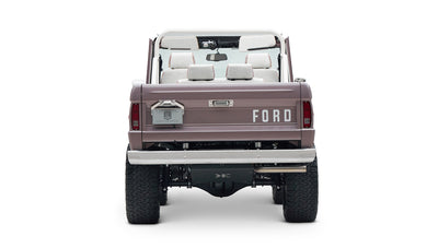 Rear view of Classic Ford Bronco in light muted purple showing tailgate with FORD lettering and off-road tires