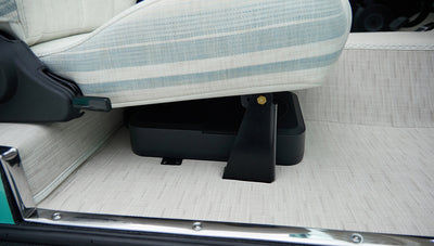Lower side view of passenger seat with striped upholstery and beige patterned floor mat in Classic Ford Bronco