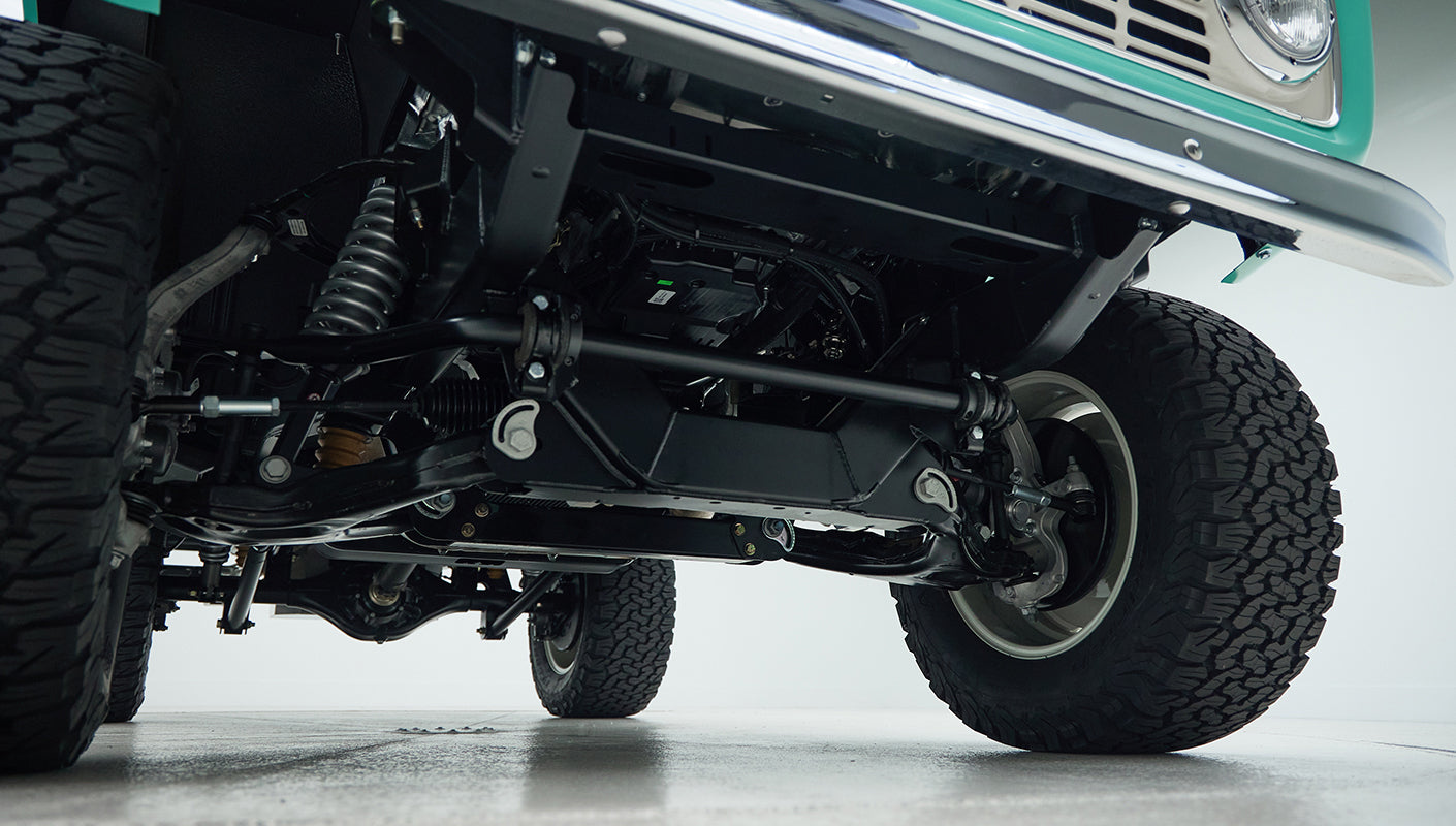 Undercarriage view showing suspension parts and off-road tires of Classic Ford Bronco