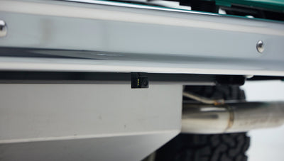 Under rear bumper showing exhaust pipe and small rear-view camera on Classic Ford Bronco