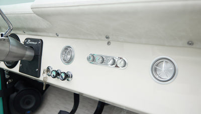 Close-up of Classic Ford Bronco dashboard showing controls, knobs, and vents in white