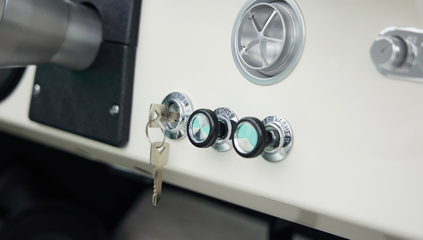 Close-up of dashboard knobs and ignition key in classic Ford Bronco interior
