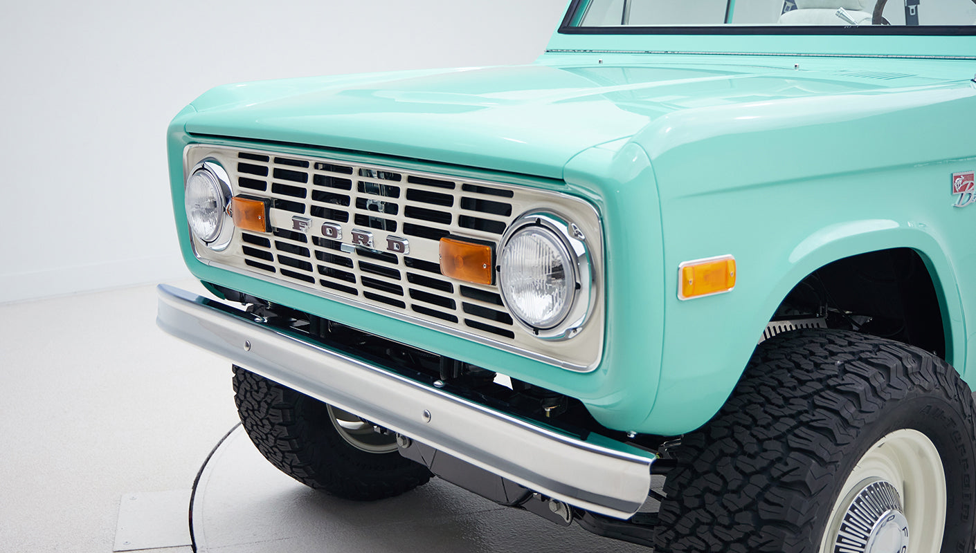 Close-up front grill and headlights of mint green Classic Ford Bronco