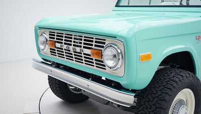 Close-up front grill and headlights of mint green Classic Ford Bronco