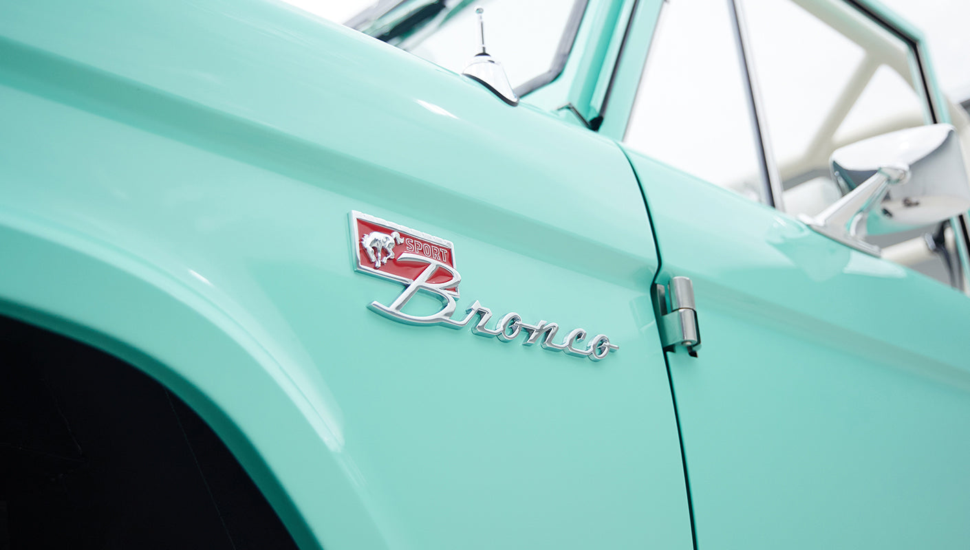 Side view of mint green Classic Ford Bronco showing Bronco emblem on fender