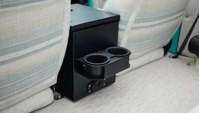 Center console area of Classic Ford Bronco with black box and dual cup holders between the front seats