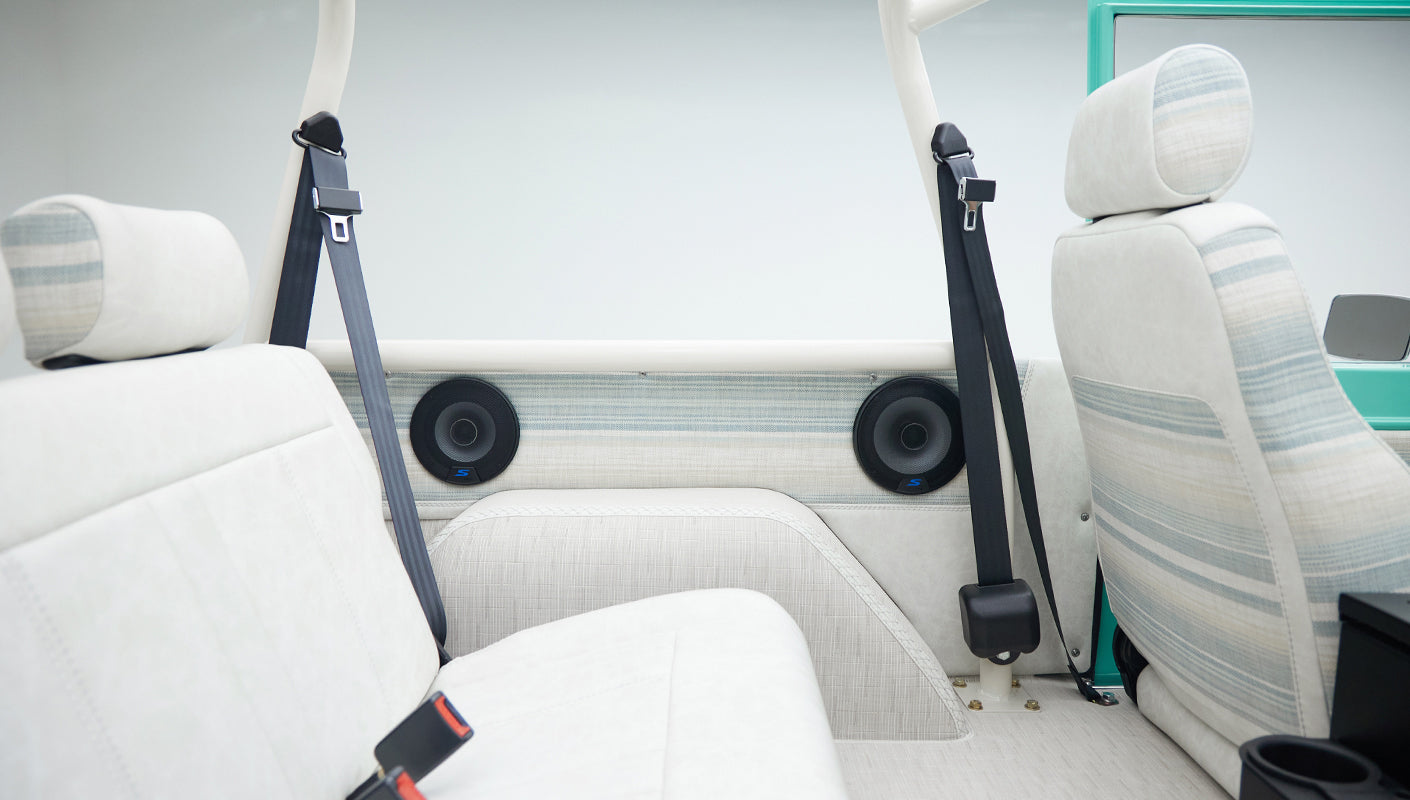 Side view of rear seat area in Classic Ford Bronco showing seat belts, upholstery and side panel speakers