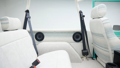 Side view of rear seat area in Classic Ford Bronco showing seat belts, upholstery and side panel speakers