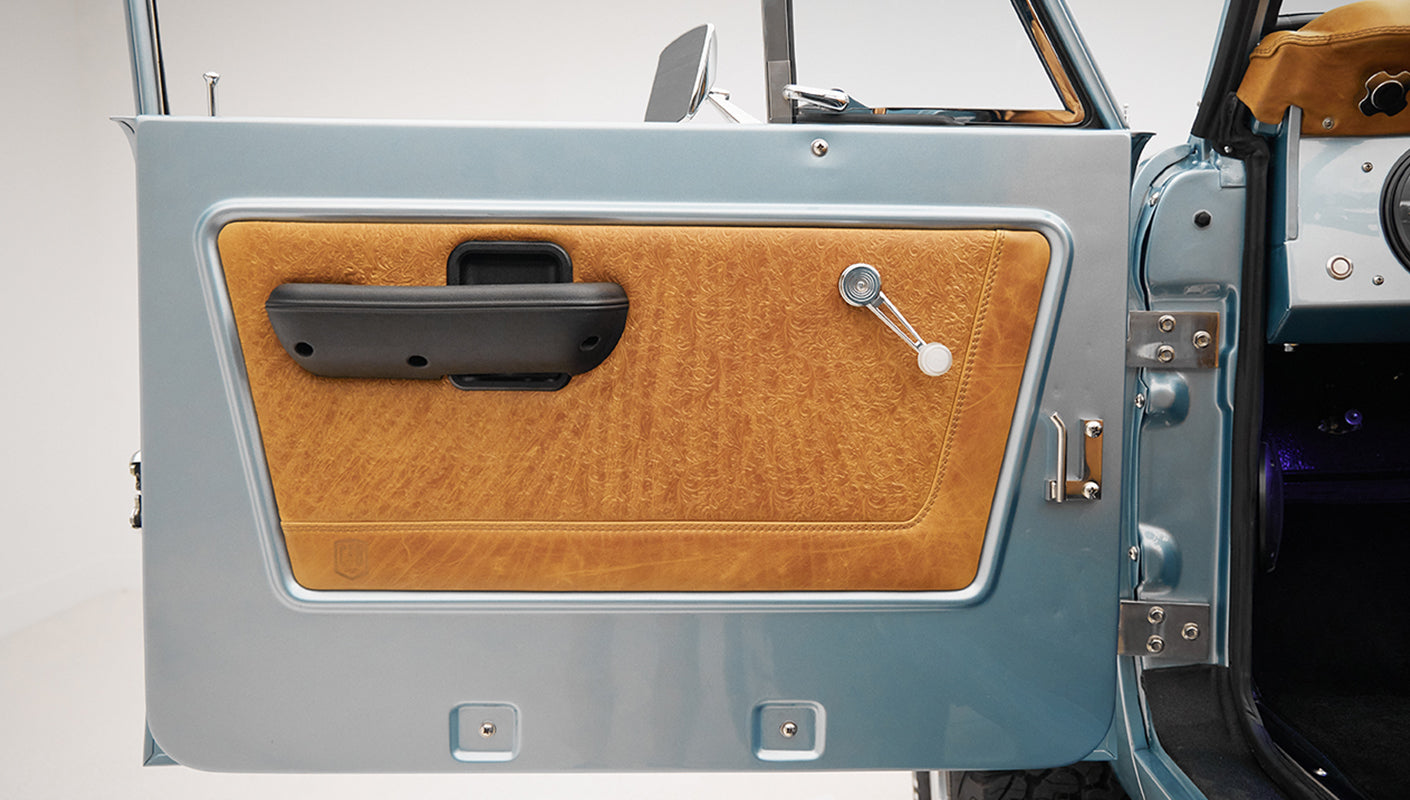 1975 ford bronco painted brittany blue with cowboy debossed, baseball stitch leather detail door panel