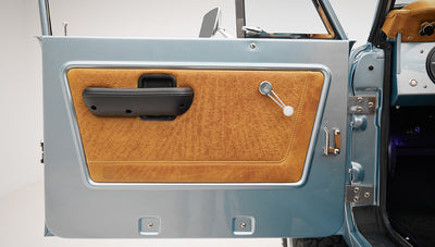 1975 ford bronco painted brittany blue with cowboy debossed, baseball stitch leather detail door panel