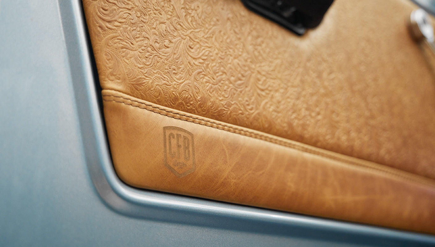 1975 ford bronco painted brittany blue with cowboy debossed, baseball stitch leather detail door panel