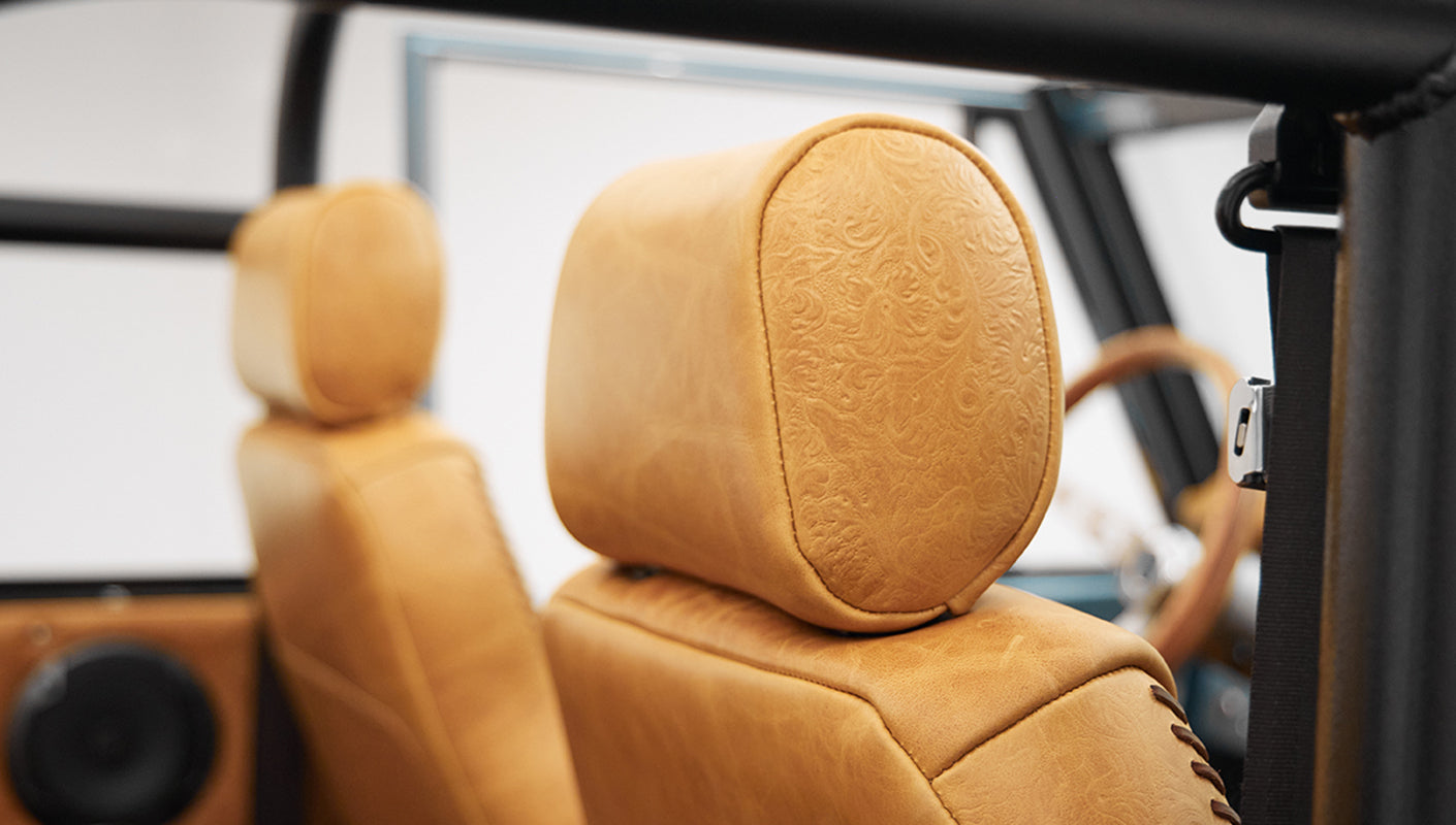 Close-up of brown leather front headrest with embossed design inside a classic Ford Bronco.