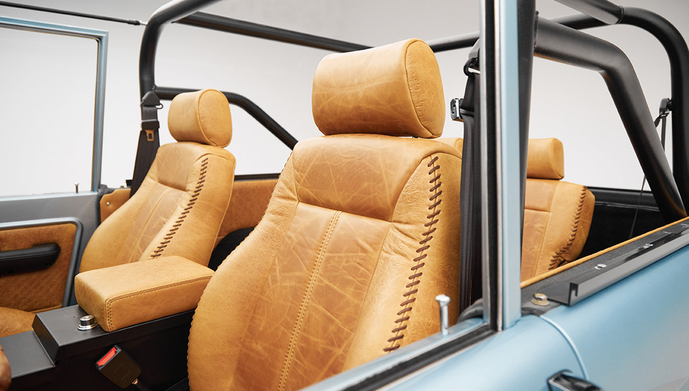 1975 ford bronco painted brittany blue with cowboy debossed, baseball stitch leather driver seat detail