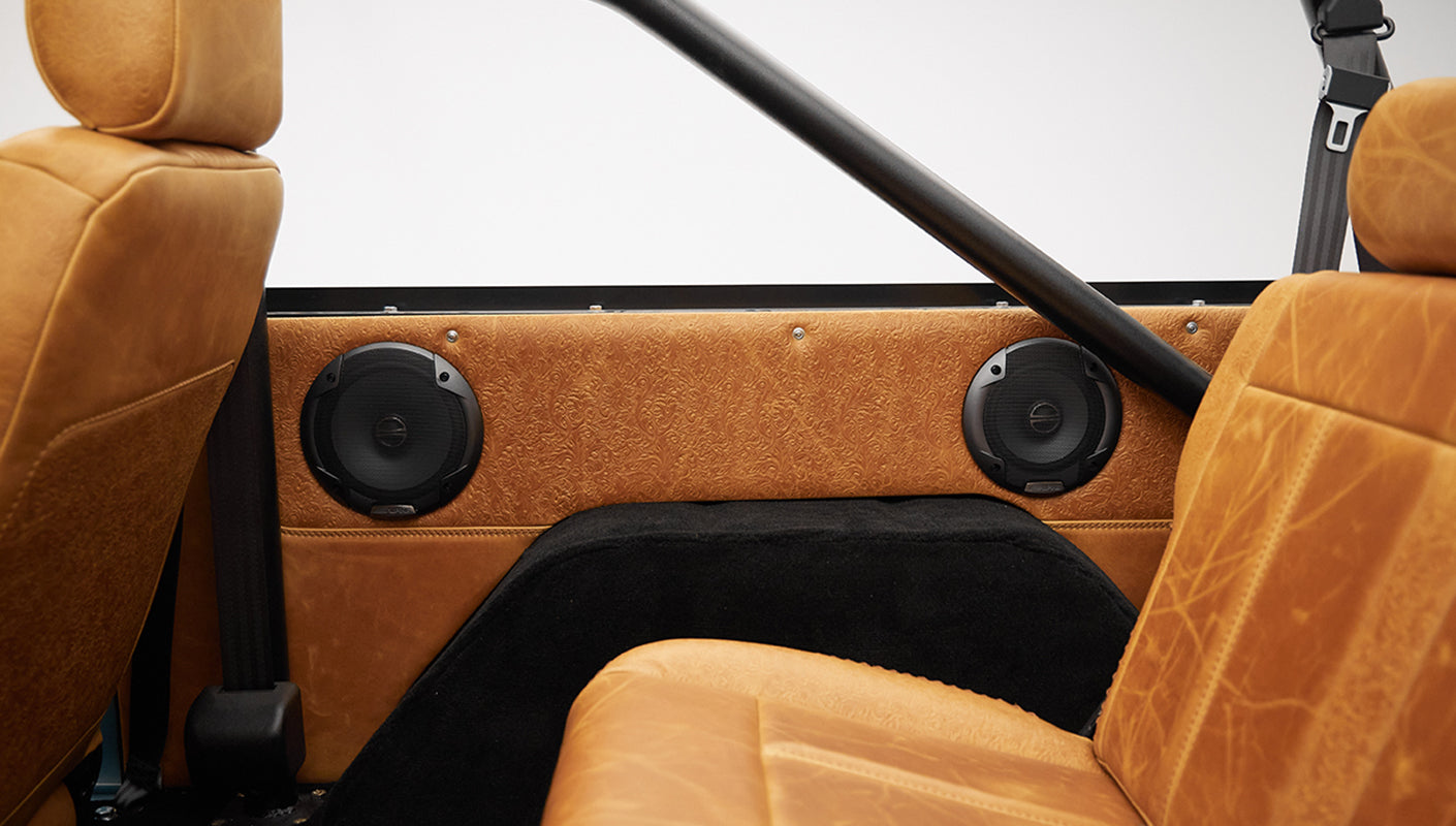 1975 ford bronco painted brittany blue with cowboy debossed, baseball stitch leather passenger speakers
