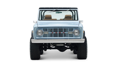 Front view of Classic Ford Bronco in light blue showing headlights, grille, and windshield