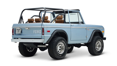 Classic Ford Bronco in Brittany Blue, rear three-quarter angled view showing tires and tailgate