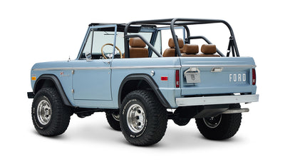 Classic Ford Bronco in Brittany Blue, rear angled view with visible roll cage and tailgate