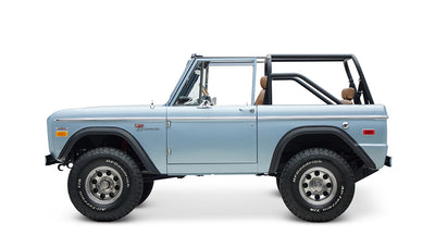 Side profile of Classic Ford Bronco in Brittany Blue with open top and lifted tires