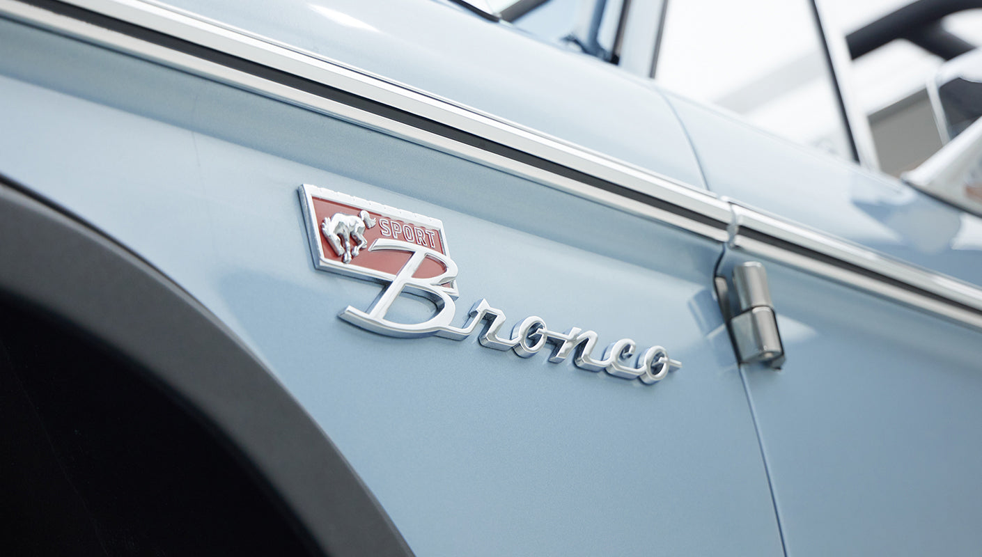 Close-up of Sport Bronco badge on front fender of light blue Classic Ford Bronco
