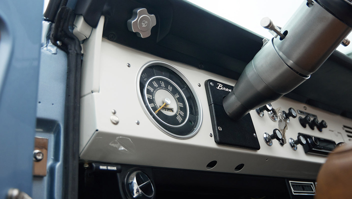Dashboard speedometer and control panel of classic Ford Bronco with black and white instruments