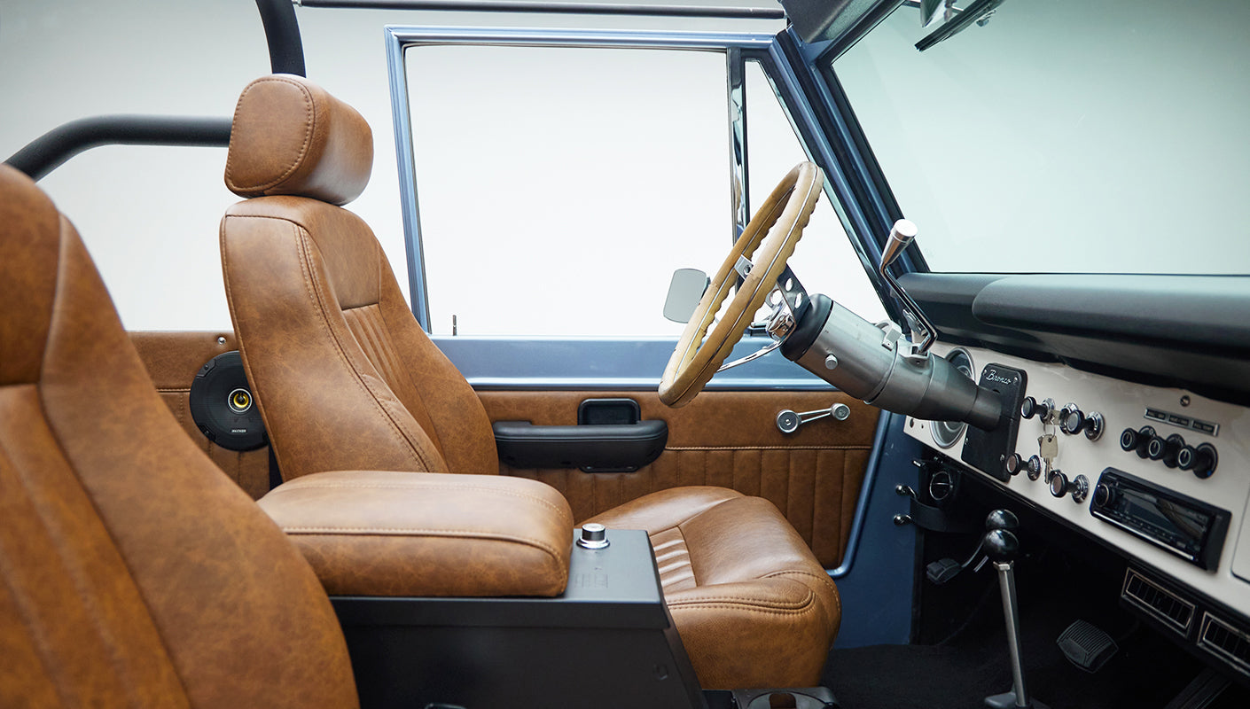 Closer look at driver side interior door panel and tan leather seat in Classic Ford Bronco