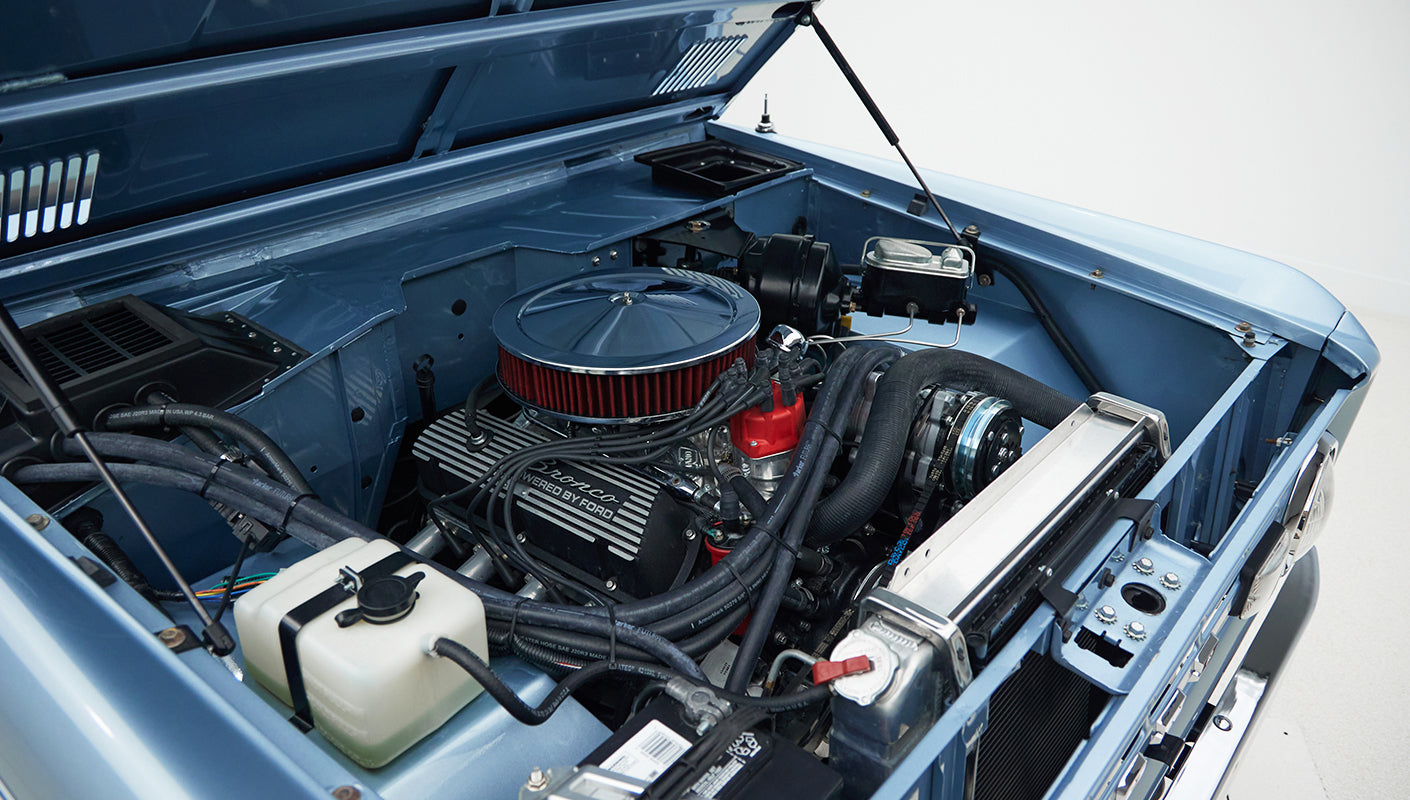 Engine compartment of Classic Ford Bronco, Brittany Blue with red air filter and black valve covers