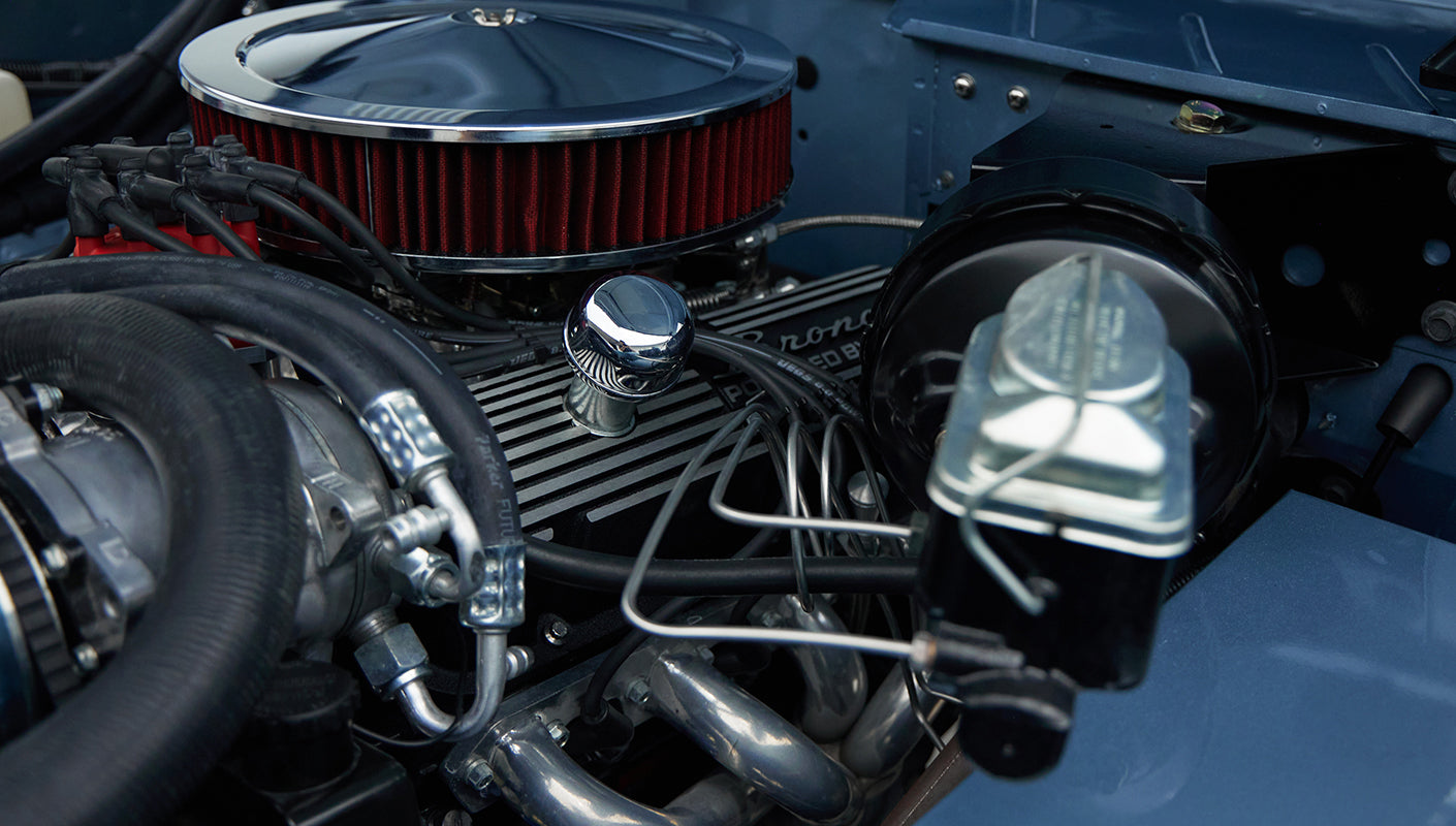 Detailed shot of engine showing valve covers with 'Bronco Powered by Ford' and red distributor