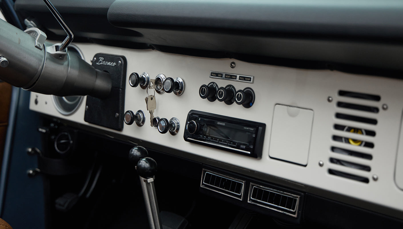 Close-up of dashboard controls, ignition keys, and air vents in Classic Ford Bronco