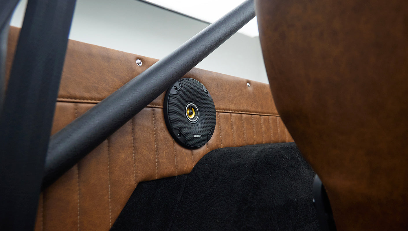 Close-up of speaker mounted on tan quilted panel inside Classic Ford Bronco rear interior