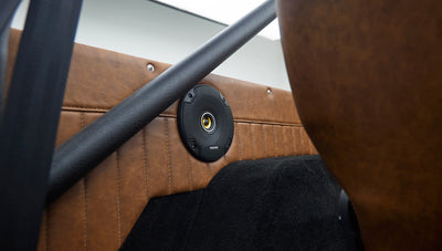 Close-up of speaker mounted on tan quilted panel inside Classic Ford Bronco rear interior
