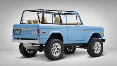 A 1976 Classic Ford Bronco is Frozen Blue over White Rock leather passenger rear 3/4