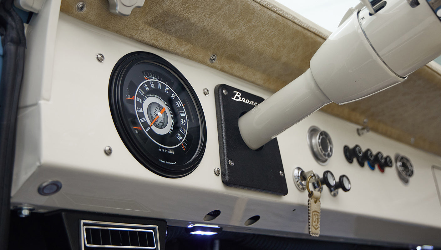 A 1976 Classic Ford Bronco is Frozen Blue over White Rock leather with custom grateful dead gauge