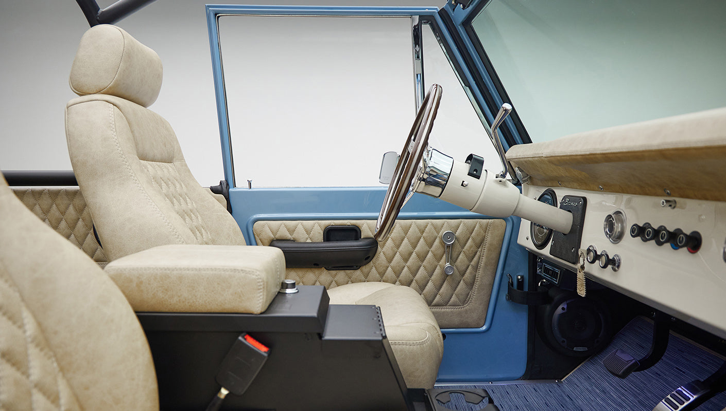 A 1976 Classic Ford Bronco is Frozen Blue over White Rock leather passenger view