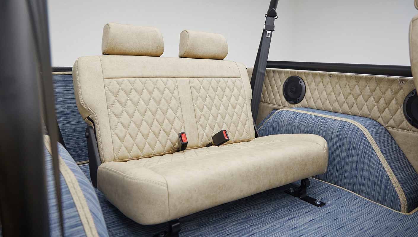 A 1976 Classic Ford Bronco is Frozen Blue over White Rock leather rear seat