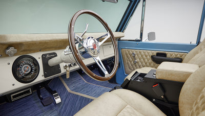 A 1976 Classic Ford Bronco is Frozen Blue over White Rock leather custom steering wheel
