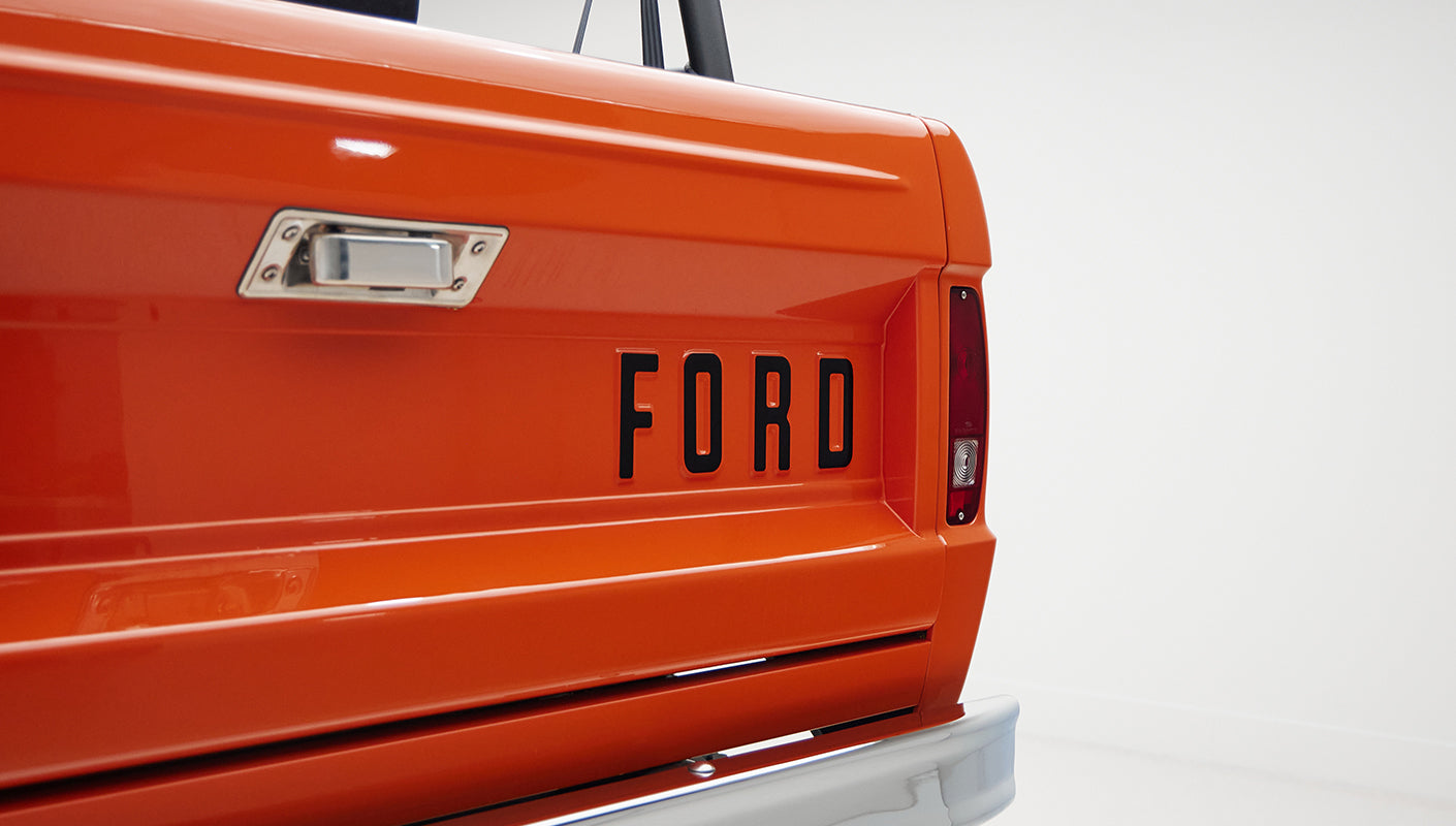 Close-up of orange tailgate with black FORD lettering on Classic Ford Bronco